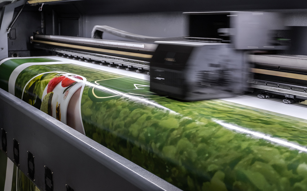 A printer is printing out a large format image that is primarily green.